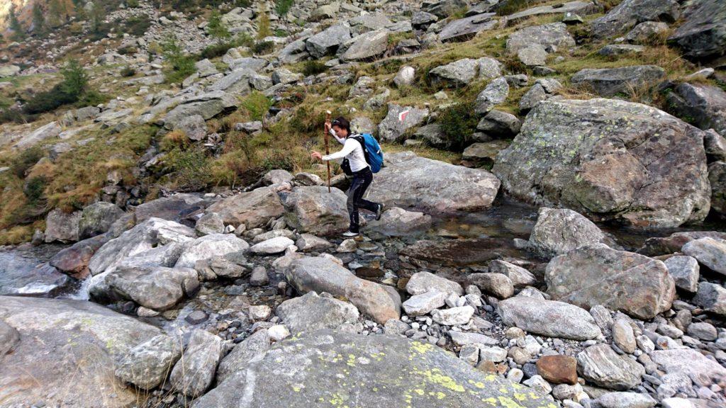 Erica guada il torrente con agilità dotata del suo bastone nuovo fiammante