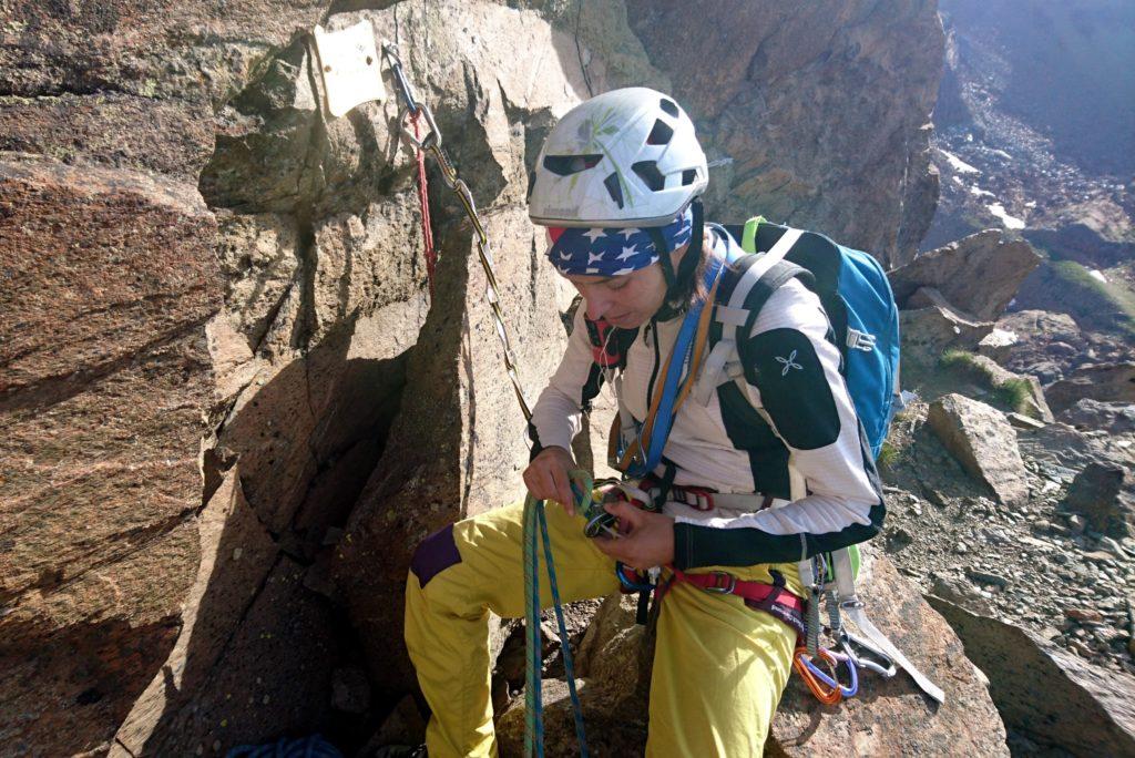L&#039;attacco è segnalato da una targa e da una scritta su roccia alla sua destra con una R e una freccia verso sinistra che indica il punto dove salire