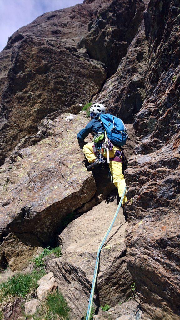 Erica attacca il quarto tiro che procede sempre verso sinistra fino alla base del camino che si intravede a monte in lontananza