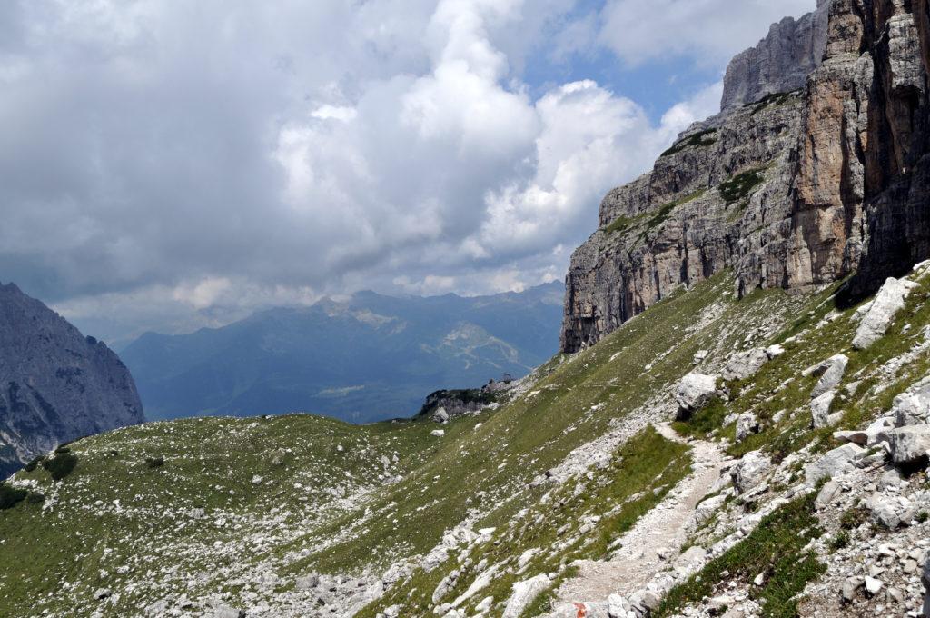 il sentiero digrada dolcemente fino al Brentei, in lontananza la cappella che lo annuncia