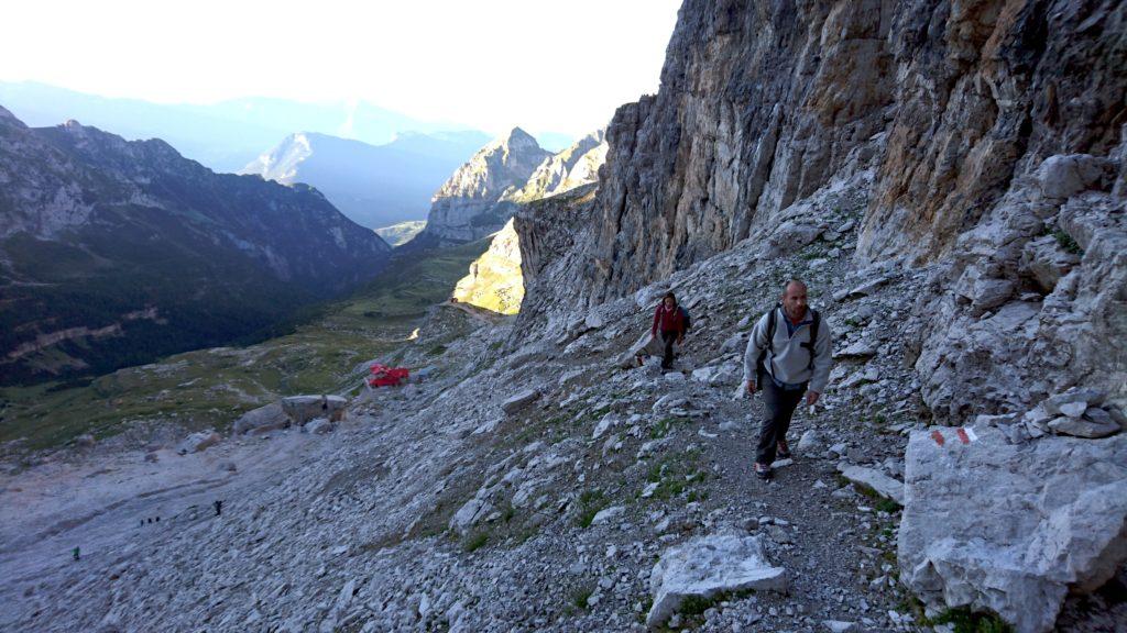 risaliamo il ghiaione alle spalle del rifugio, che si vede in lontananza grazie al colore vivace del tetto