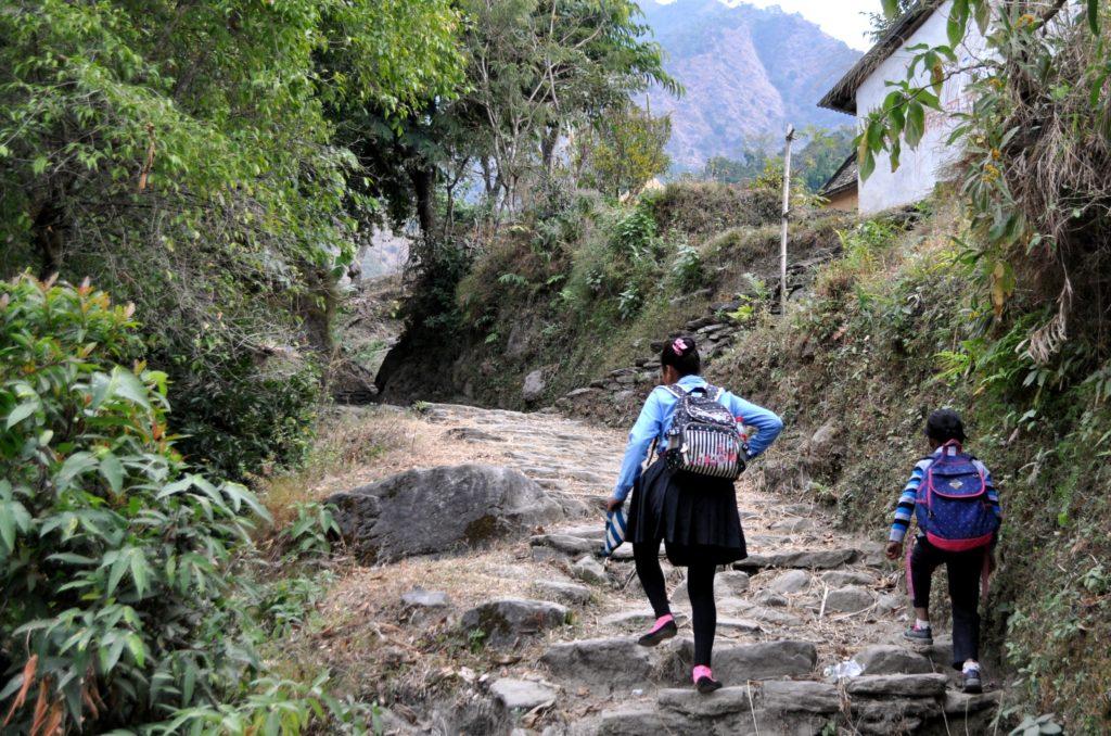 due bambine in uniforme affrontano il sentiero verso la scuola che si trova in cima alla collina. Tutti i giorni si fanno un&#039;ora di cammino in salita e in discesa!