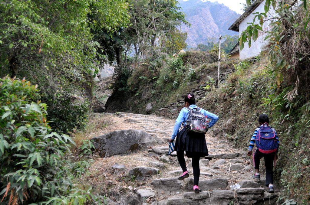 due bambine in uniforme affrontano il sentiero verso la scuola che si trova in cima alla collina. Tutti i giorni si fanno un'ora di cammino in salita e in discesa!