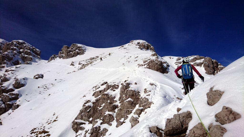 Ci siamo quasi. Dobbiamo raggiungere quel colletto nevoso che si vede a sinistra e poi affrontare l'ultima parte di roccette fino alla cima