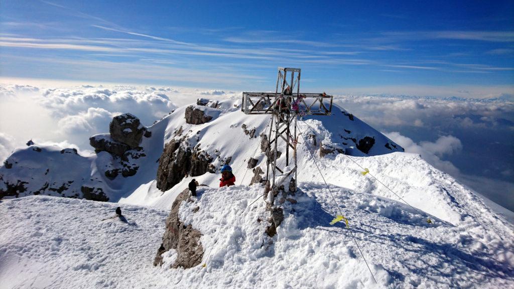 Il Galletto con i gracchi di vetta che cercano di scroccargli da mangiare e la croce della cima