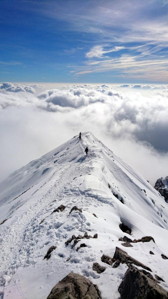 Siamo in discesa. Bellissima vista della Cermenati prima di sprofondare tra le nubi. Ci dirigiamo verso l'attacco del canale Caimi che ci permetterà una rapida discesa