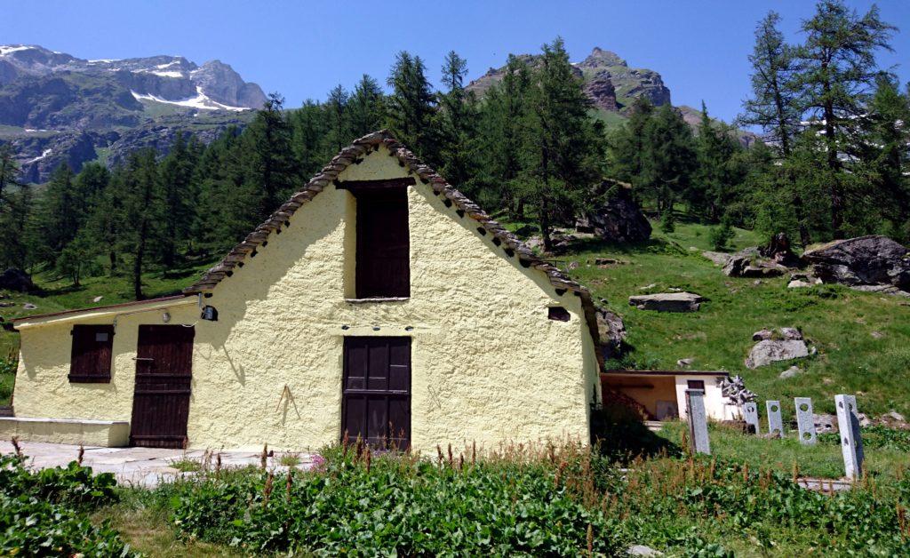 la casetta gialla dell'attacco del sentiero: in sostanza da qui bisogna risalire dritti per prati fino alla sommità del promontorio boscato (e non prendere la traccia più evidente che gira verso destra, immettendosi nella valle di fianco)