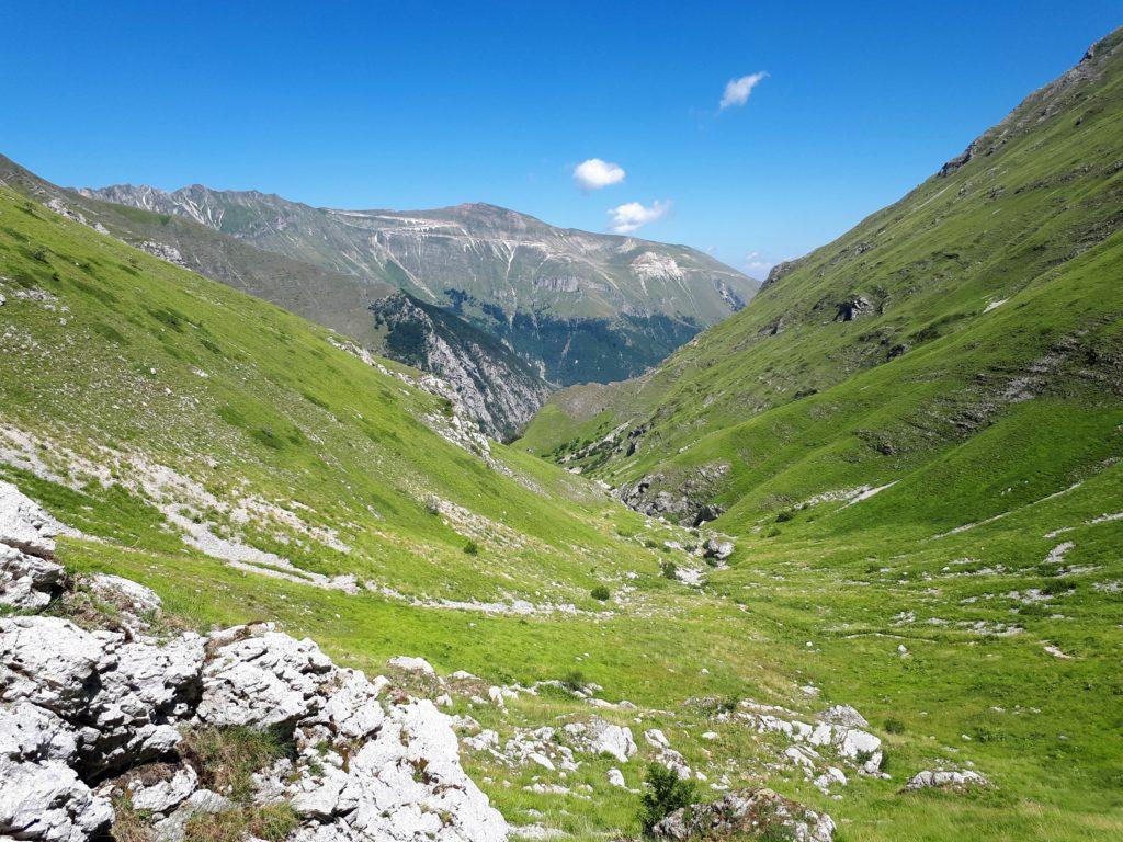 la valle nella sua parte più alta, sullo sfondo il Monte Sibilla tagliato dai tornanti della strada