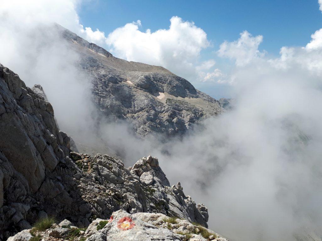 i segnavia della Ferrata Danesi, e le nubi che cominciano ad addensarsi sulla cima