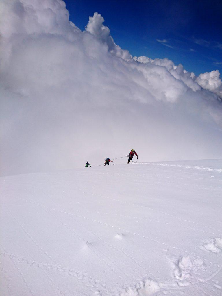 La cordata Paolo, Roberto, Stefano in uscita sulla cresta con i nuvoloni che incombono