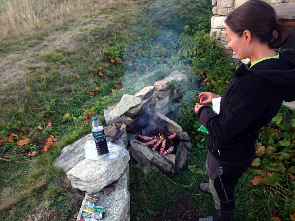 Erica controlla la cottura della carne e intanto facciamo aperitivo col vinello portato da casa