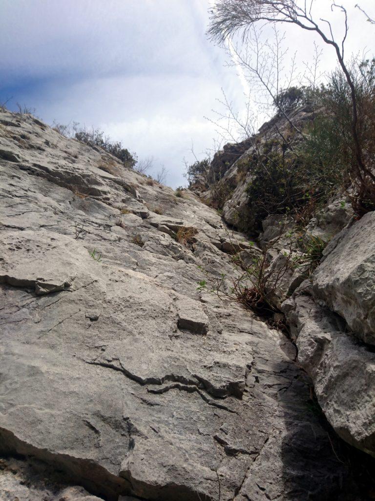 Saltiamo in avanti e arriviamo alla base del camino del penultimo tiro, facile ma con pericolo di caduta massi