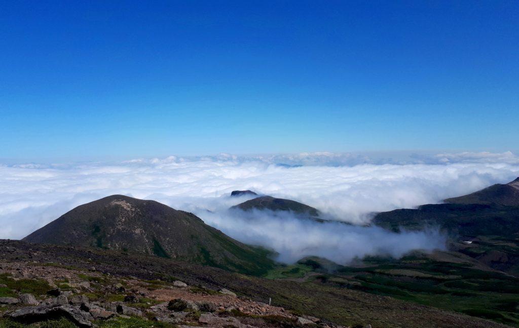 sulla cima dell&#039;Hokuchindake, il letto di nubi ancora avvolge le valli