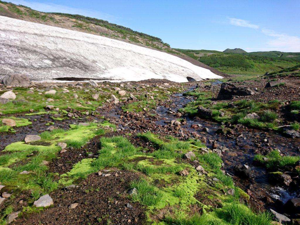 prima di riguadagnare la valle, qui solcata da corsi d'acqua e con qualche nevaietto