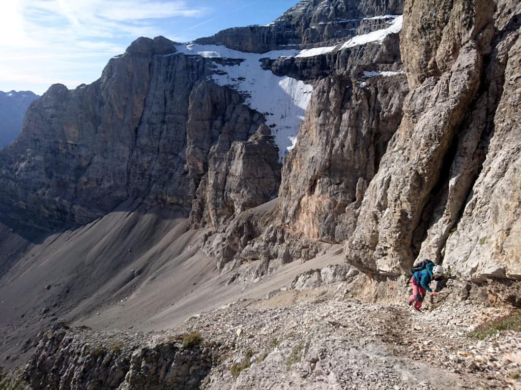 si segue poi ancora per sfasciumi in direzione opposta stando accanto alla roccia fino a raggiungere il diedro d'attacco