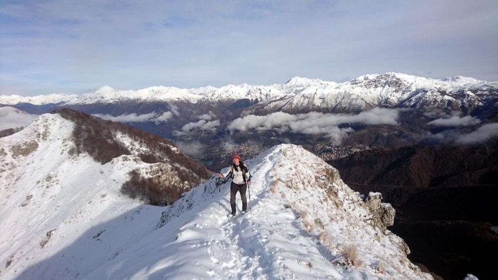 Erica giunta in cresta e sullo sfondo da destra lo zucco Campelli, al centro il Tre Signori e a sinistra il Legnone