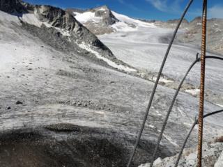 l'incredibile ritirata del ghiacciaio sotto al Rifugio Lobbia Alta, che lascia scoperta una porzione di terra e detriti