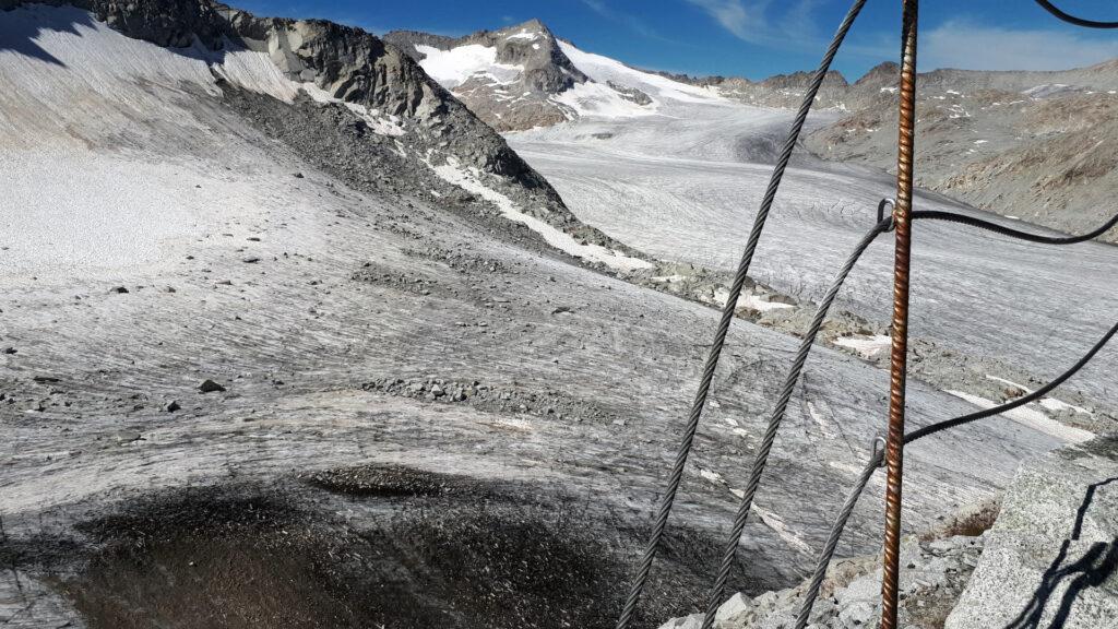 l'incredibile ritirata del ghiacciaio sotto al Rifugio Lobbia Alta, che lascia scoperta una porzione di terra e detriti