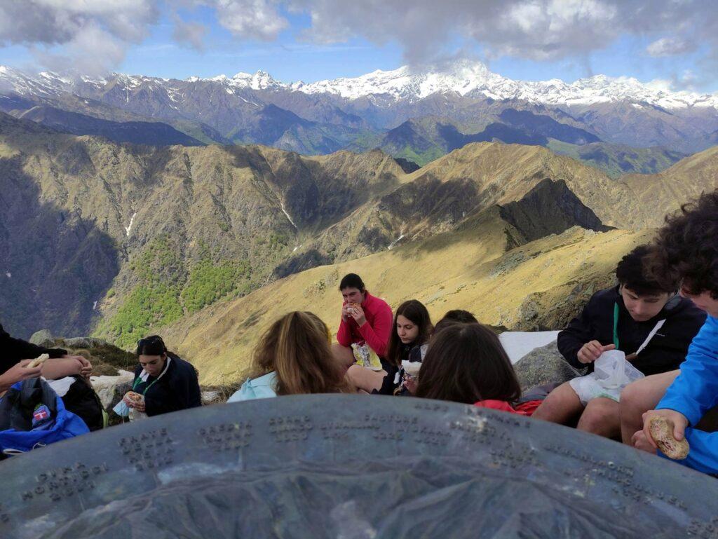 La rosa delle cime, un gruppo scout che pranza in vetta e il Monte Rosa sullo sfondo