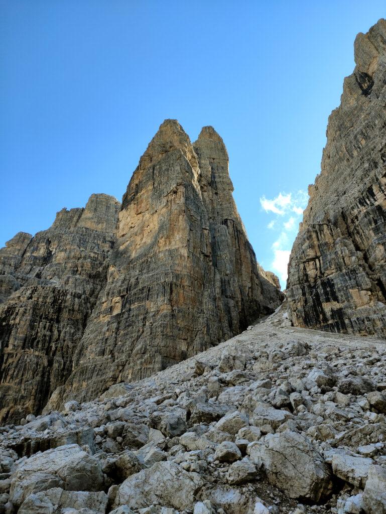 risalendo il ghiaione verso Bocca di Brenta si passa di fianco al Campanile Basso: una cordata è impegnata nei primi tiri di quella che potrebbe essere la Fermann