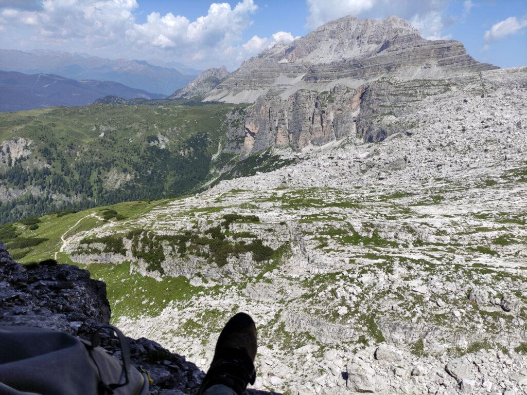 Gab svaccato sulla quarta cengia in riposo, guardando la Corna Rossa e la Pietra Grande sullo sfondo