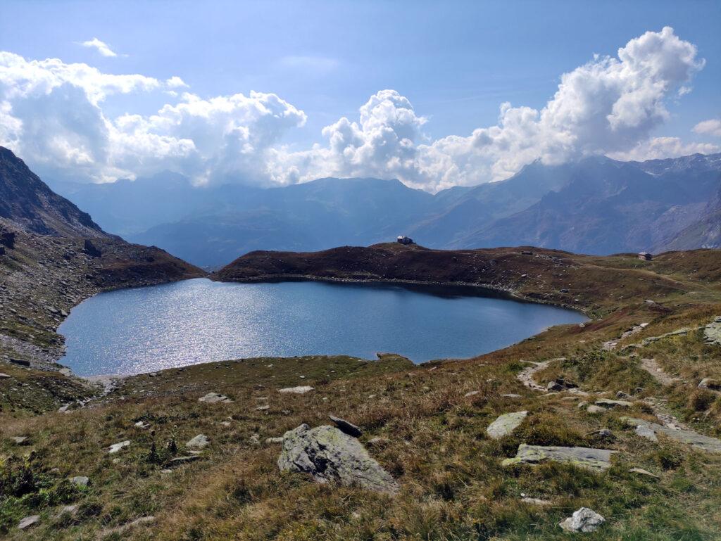 Dopo lunghe, ripide e faticose pietraie eccoci finalmente al lago di Emet dietro a cui sorge il rifugio Bertacchi