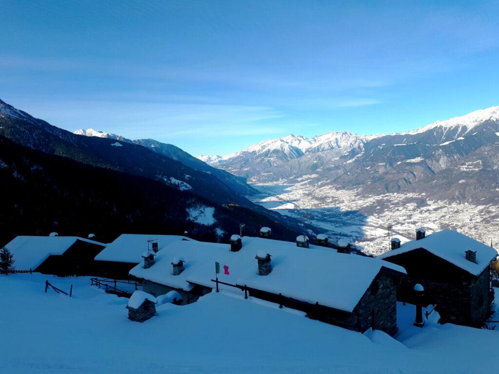 Le case della località Campelli con la luce del mattino e la Valtellina sullo sfondo