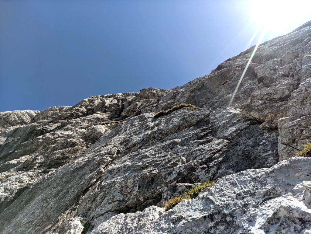 Vista del sesto tiro dalla sosta: rampa ascendente verso sinistra che porta alla base del camino finale