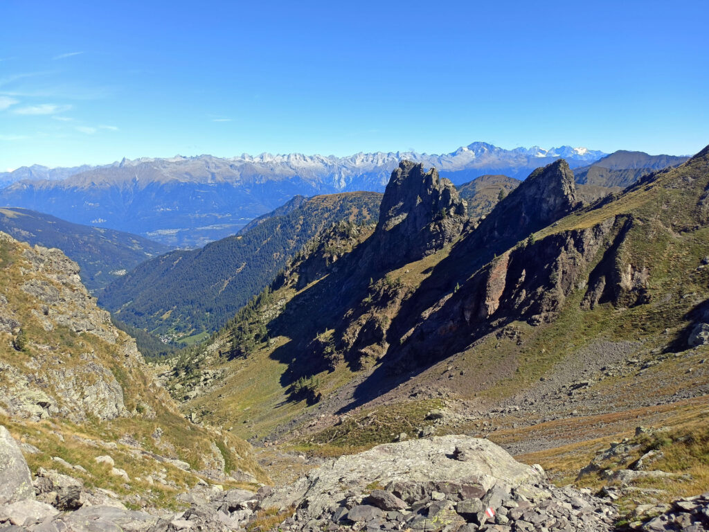 risalendo il canalino e guardano verso la Val Tronella, in primo piano i Denti della Vecchia, laggiù all'orizzonte il Disgrazia