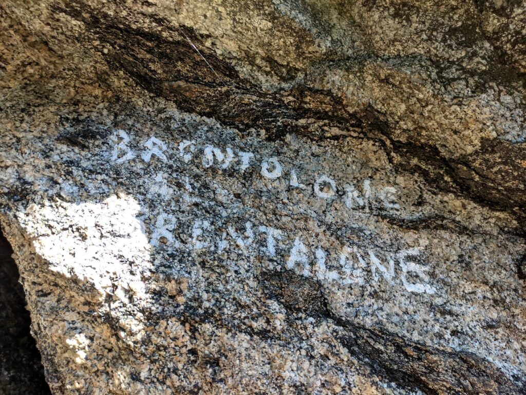 Il nome della via è scritto in bianco sulla roccia accanto allo spigolo