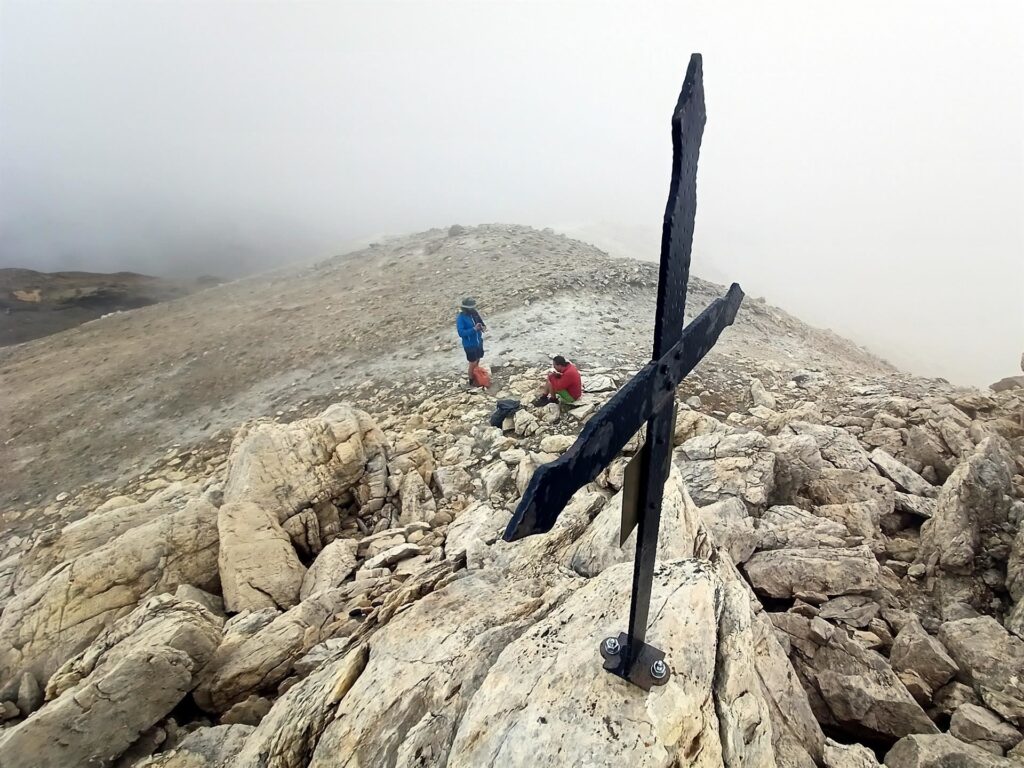 La croce appena sopra alle guglie che in realtà non rappresenta una cima vera e propria ma che consente di compilare il libro di vetta