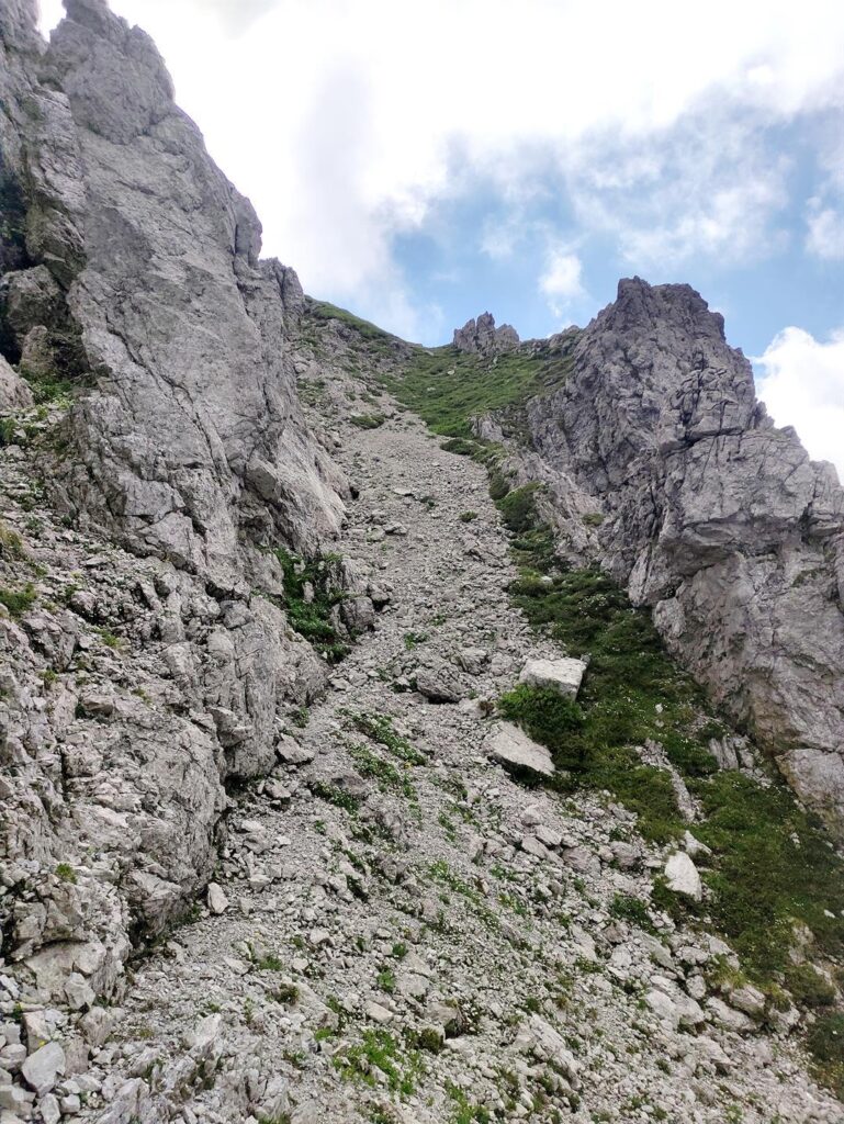 Per uscire sulla cima si può scalare in conserva un ampio camino a sinistra di questa immagine oppure prendere l'evidente rampa che in circa 100m porta più velocemente in vetta