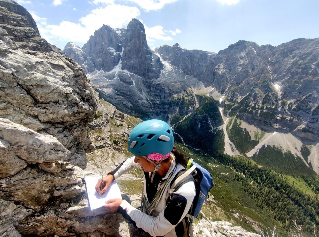 Erica firma il libro di vetta con il Crozzon sullo sfondo