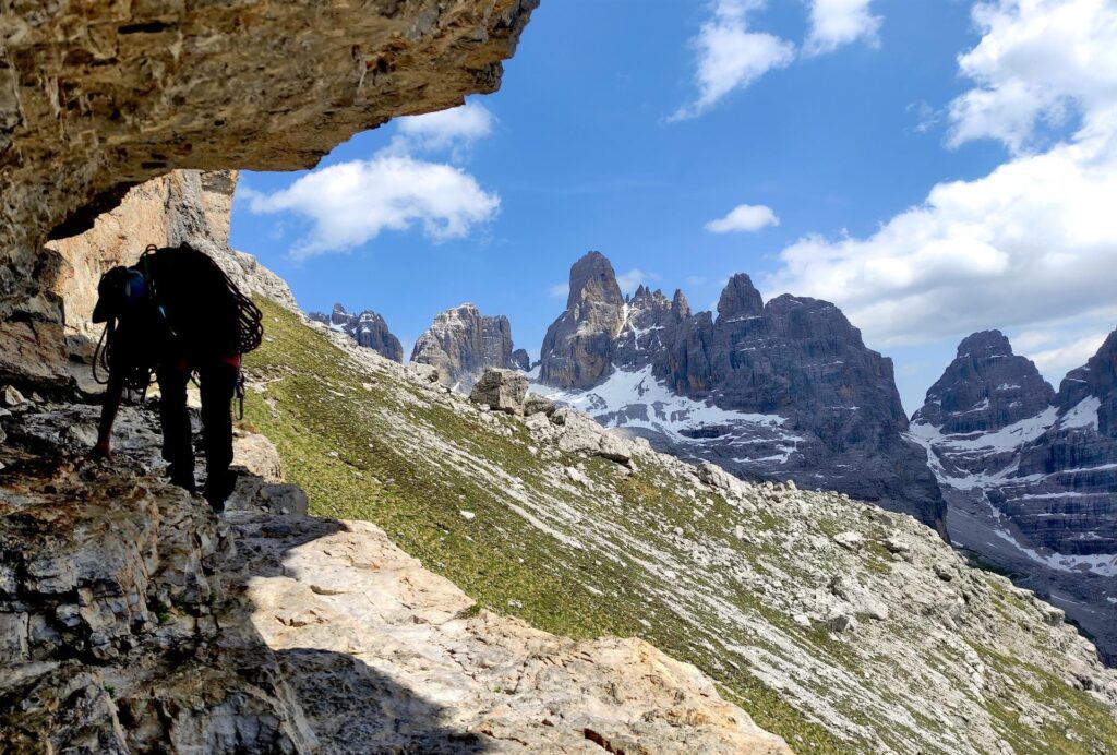 Il classico passaggio della Sosat dove bisogna piegarsi per passare con sullo sfondo il panorama del Brenta Centrale