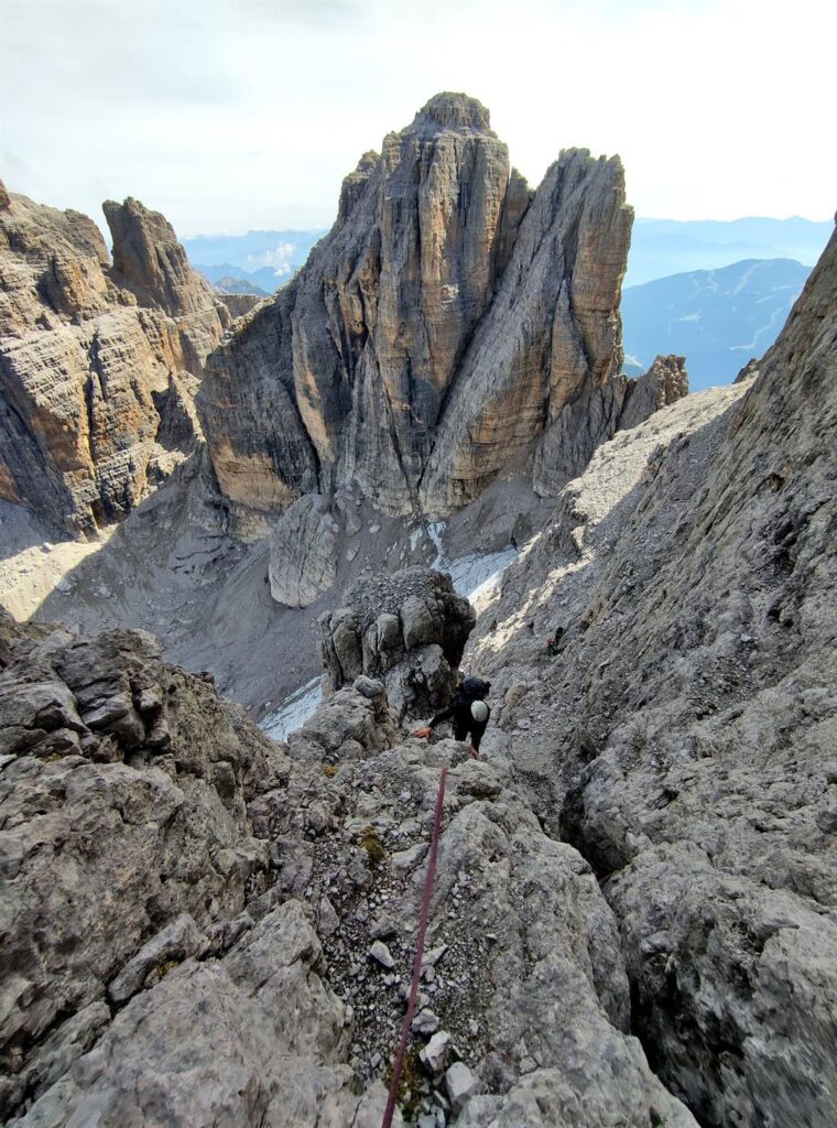 Andre sul tratto finale del primo tiro di camino con la Cima degli Armi sullo sfondo