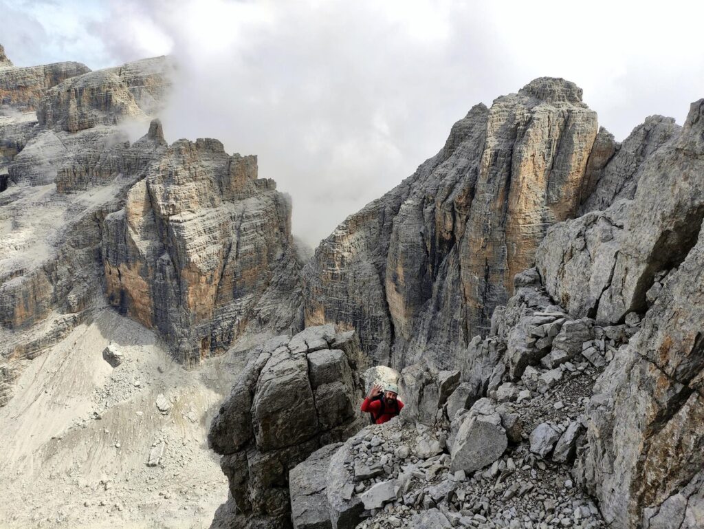 Il Niggah saluta uscendo dal camino con Cima Molveno e Cima degli Armi sullo sfondo