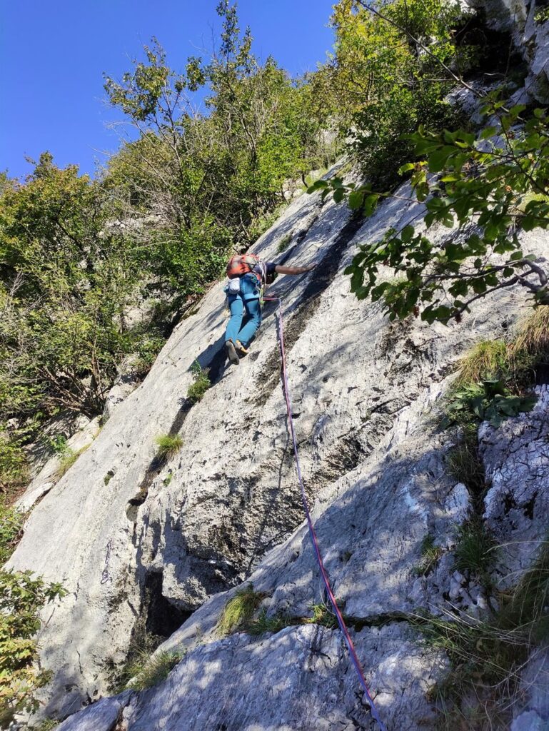 Secondo tiro di Foto di gruppo: ci si sposta a sinistra salendo questa placca lavorata fino alla sosta