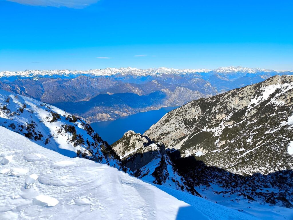 Guardando verso nord ovest, oltre allo scorcio del Garda si vedono sullo sfondo il Brenta, e la catena della Presanella e dell&#039;Adamello
