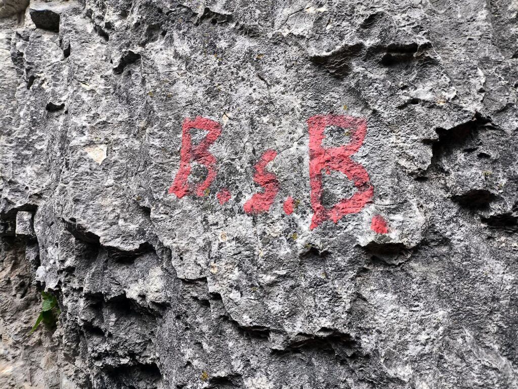 La sigla che identifica l&#039;attacco della via, ben evidente sulla roccia