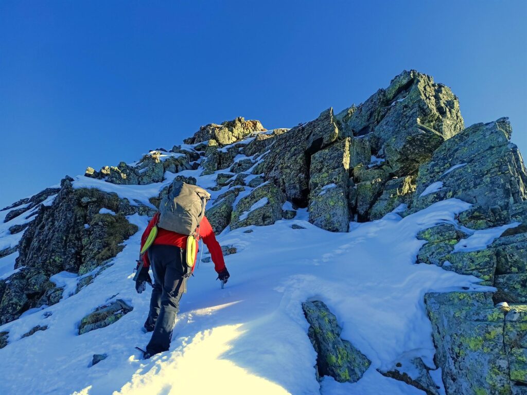 Torniamo sul lato nord per affrontare le ultime roccette + neve che conducono verso la vetta Torniamo sul lato nord per affrontare le ultime roccette + neve che conducono verso la vetta