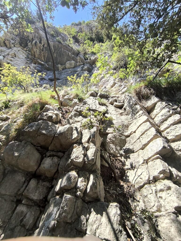 Ecco la foto del punto di attacco della via, con i massi a forma di mattone e l'ampio tetto sopra Ecco la foto del punto di attacco della via, con i massi a forma di mattone e l'ampio tetto sopra