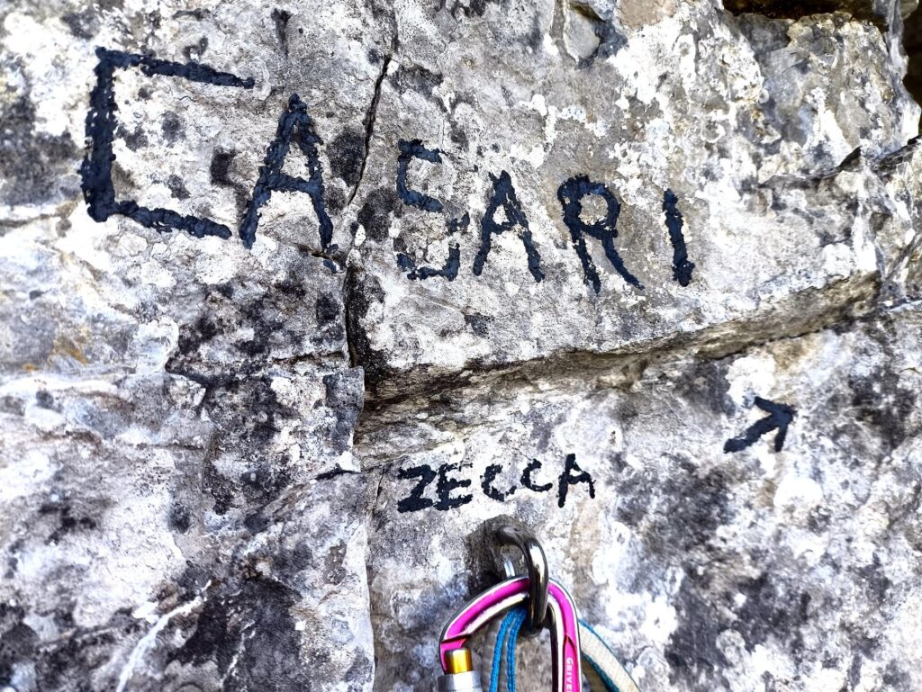 Traversata la cengia si incontra la scritta con l'attacco della Casari-Zecca Traversata la cengia si incontra la scritta con l'attacco della Casari-Zecca