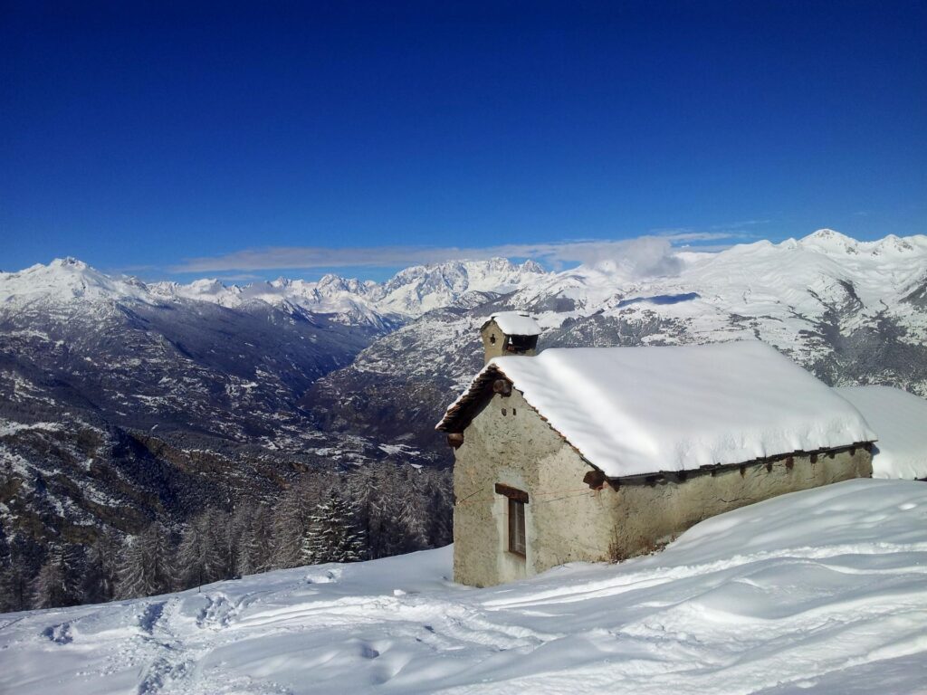 Guardando verso valle dall'alpeggio, solo il Monte Bianco e il Grand Jorasses si nascondono dietro a una sottile nuvoletta, che presto comunque sparir&agrave; per regalarci la skyline completa