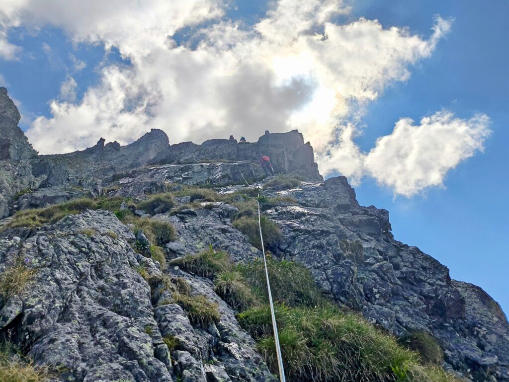 Il secondo tiro: si procede per rocce e erba superando un ultimo risalto fino ad arrivare alla sosta Il secondo tiro: si procede per rocce e erba superando un ultimo risalto fino ad arrivare alla sosta