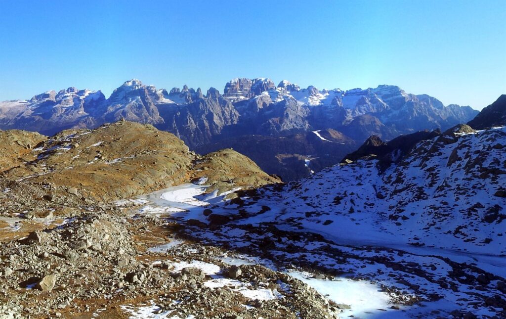 Ci alziamo quindi lungo la morena e godiamo alle nostre spalle del bellissimo paesaggio offerto dalle dolomiti di Brenta Ci alziamo quindi lungo la morena e godiamo alle nostre spalle del bellissimo paesaggio offerto dalle dolomiti di Brenta
