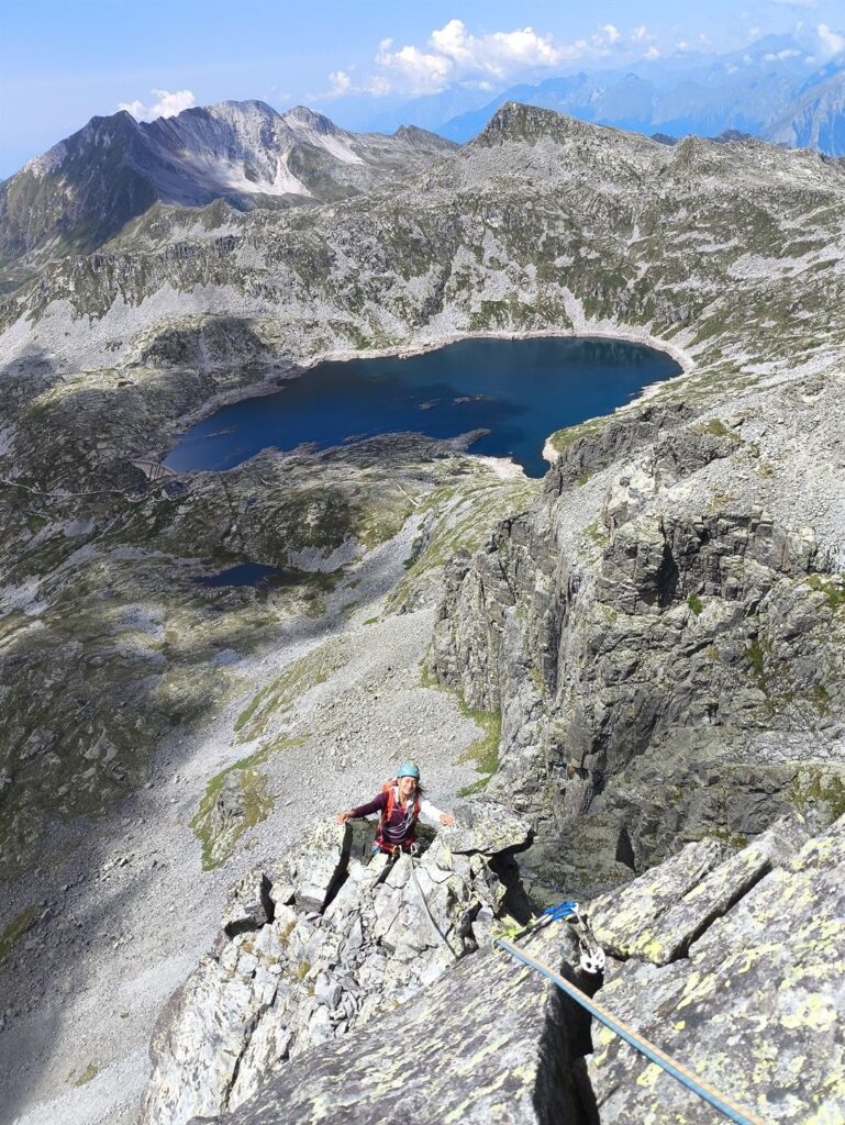 Erica sorridente con lo spettacolare paesaggio visibile dalla cresta al termine del sesto tiro dello spigolo Maffei Erica sorridente con lo spettacolare paesaggio visibile dalla cresta al termine del sesto tiro dello spigolo Maffei