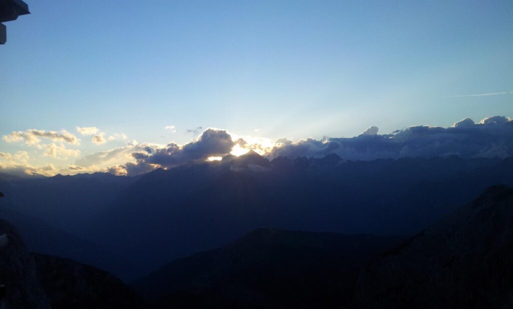 Il sole tramonta esattamente dietro alla Presanella, che ben si riconosce sul lato opposto della valle