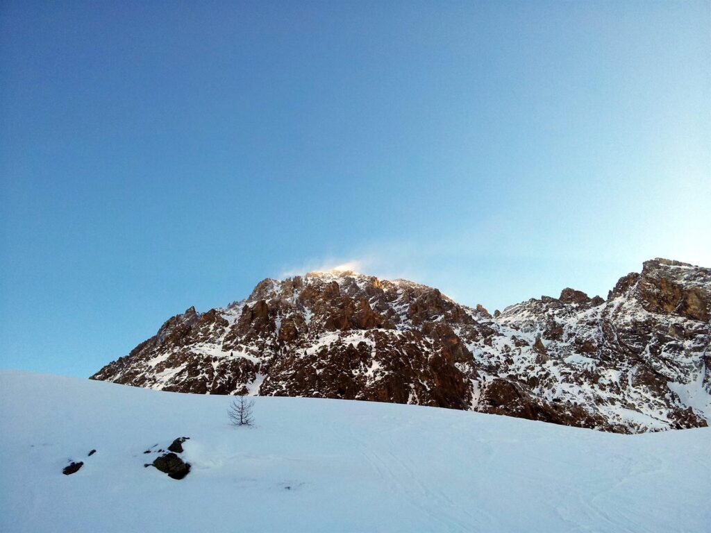 Ecco la cima dello Chaberton, battutissima dal vento che oggi è veramente forte e ci crea non pochi problemi. Anche dal basso, capiamo subito che se mai riusciremo ad arrivare su, non sarà sicuramente una passeggiata Ecco la cima dello Chaberton, battutissima dal vento che oggi è veramente forte e ci crea non pochi problemi. Anche dal basso, capiamo subito che se mai riusciremo ad arrivare su, non sarà sicuramente una passeggiata