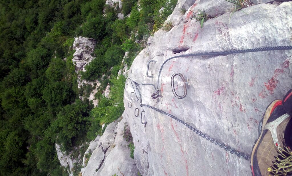 Foto del muro verticale/strapiombante che si trova dopo il traverso. Qui ho dovuto usare anch'io le staffe perché la placca è bella liscia e levigata. Forse con le scarpette si poteva tentare di non usare i pioli, ma nessuna voglia di cacciarle fuori dallo zaino Foto del muro verticale/strapiombante che si trova dopo il traverso. Qui ho dovuto usare anch'io le staffe perché la placca è bella liscia e levigata. Forse con le scarpette si poteva tentare di non usare i pioli, ma nessuna voglia di cacciarle fuori dallo zaino