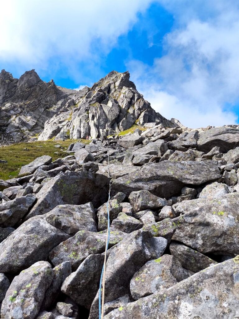 Questo è il tiro di raccordo. Per evitare l'erba si passa su questa pietraia fino alla base della balza successiva Questo è il tiro di raccordo. Per evitare l'erba si passa su questa pietraia fino alla base della balza successiva